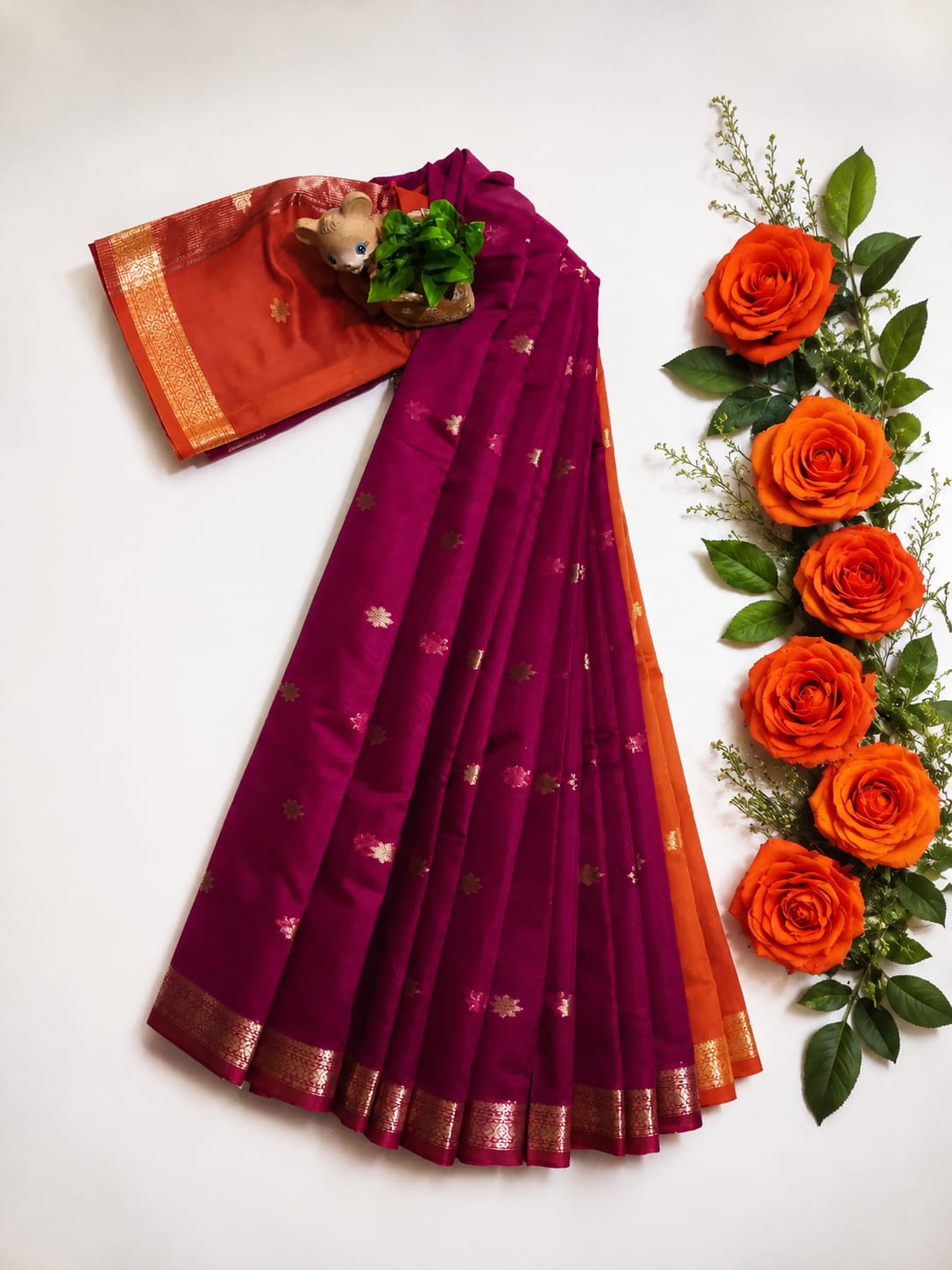 Maheshwari silk-cotton saree presented in a deep magenta hue. It is adorned with gold zari