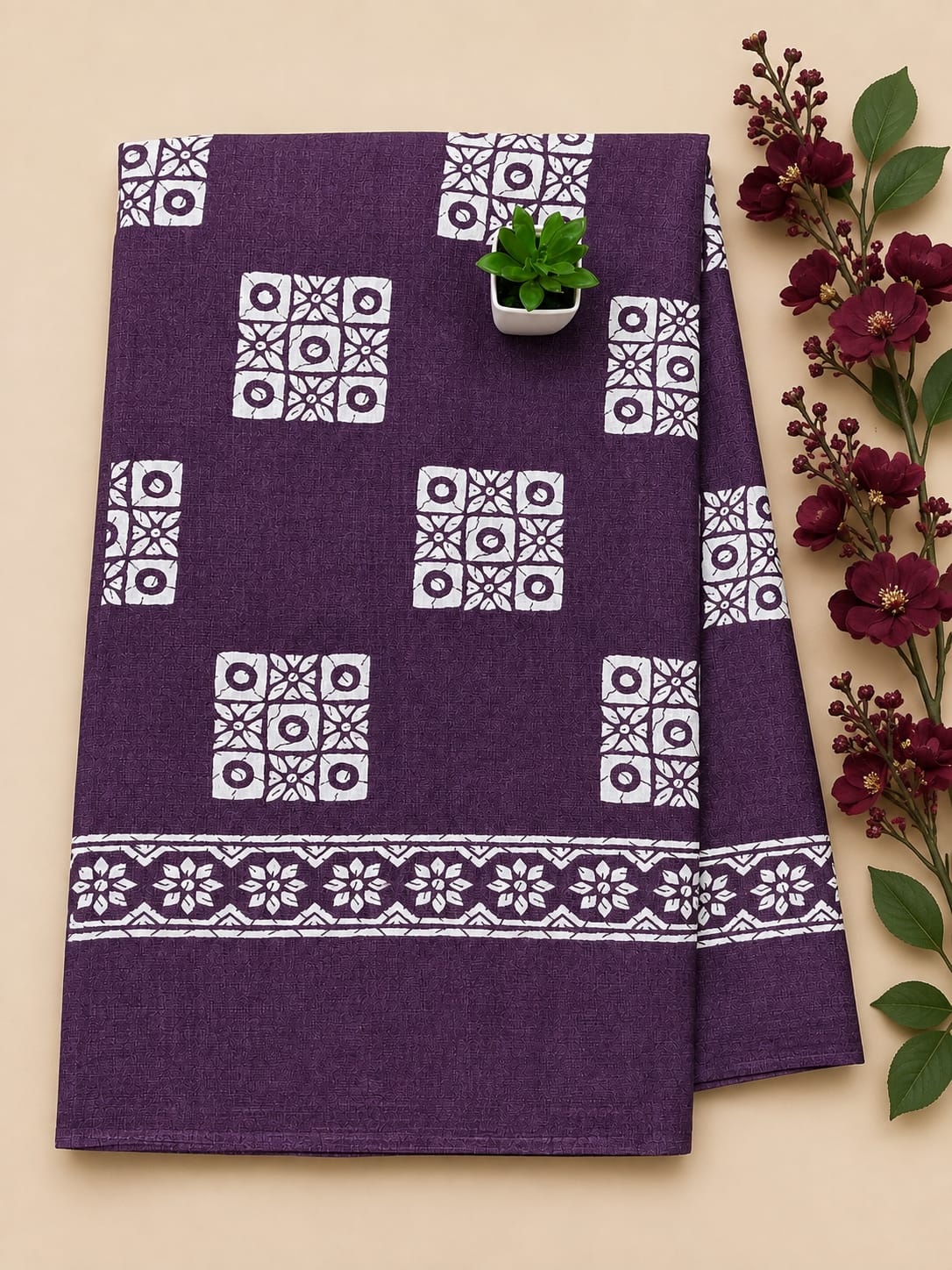Stunning purple cotton dress material features intricate white block prints, including geometric patterns on the body and elaborate traditional motifs along the border