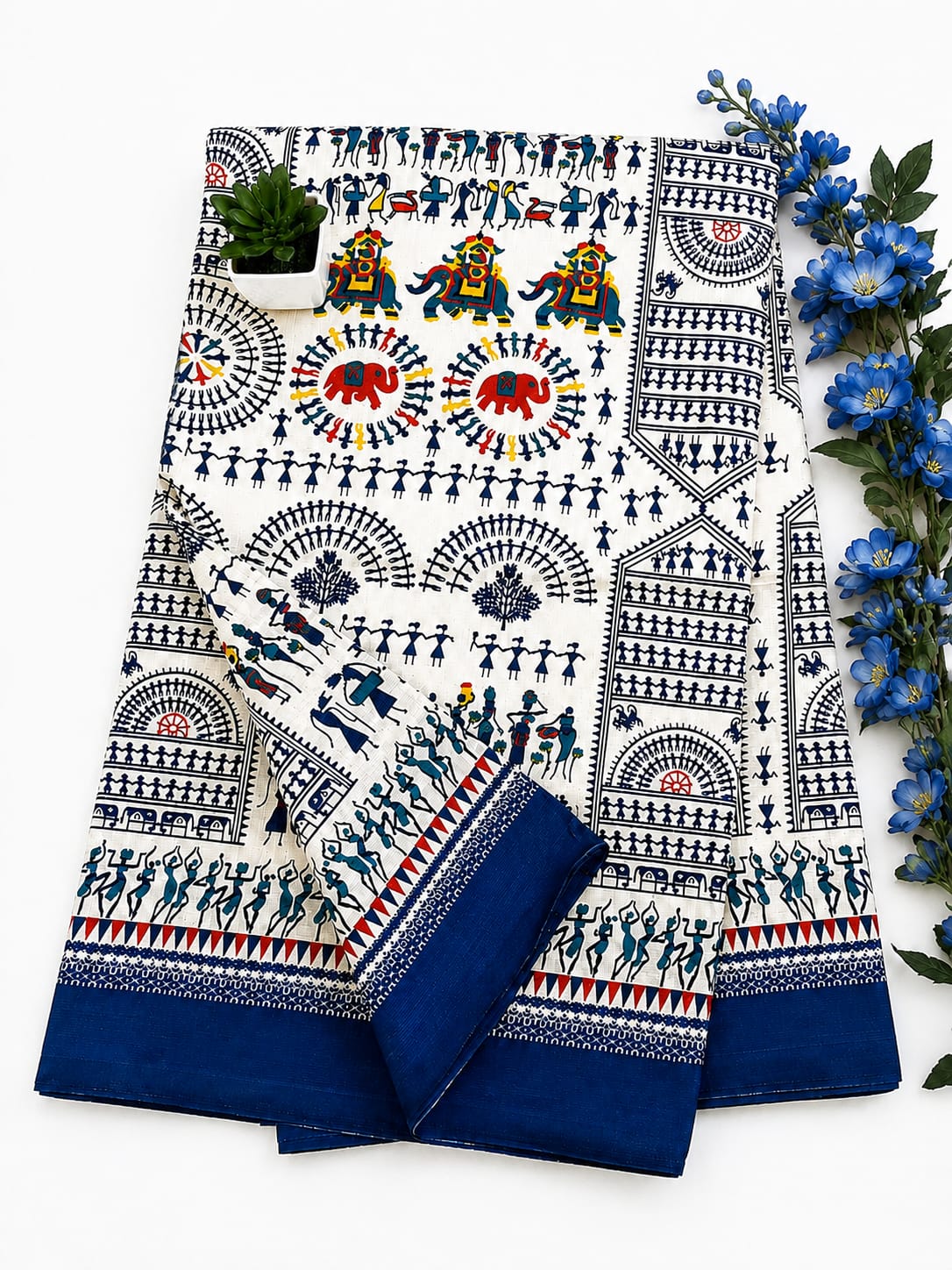 Cream and blue traditional saree features intricate Warli folk art prints, traditional geometric and tribal motifs, and a solid navy-blue border